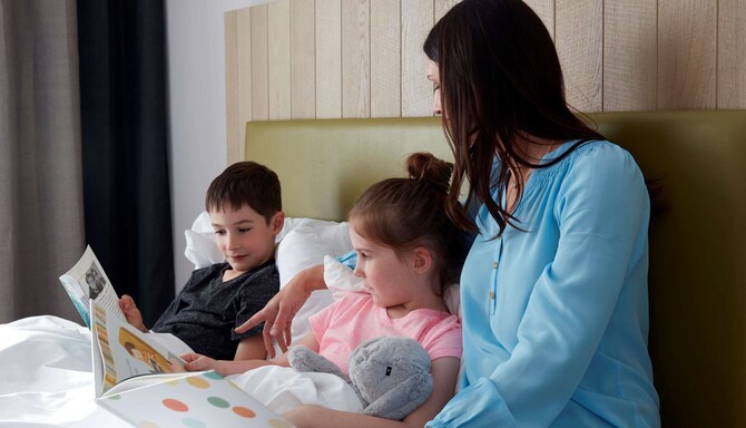 Mor och barn som läser i sängen