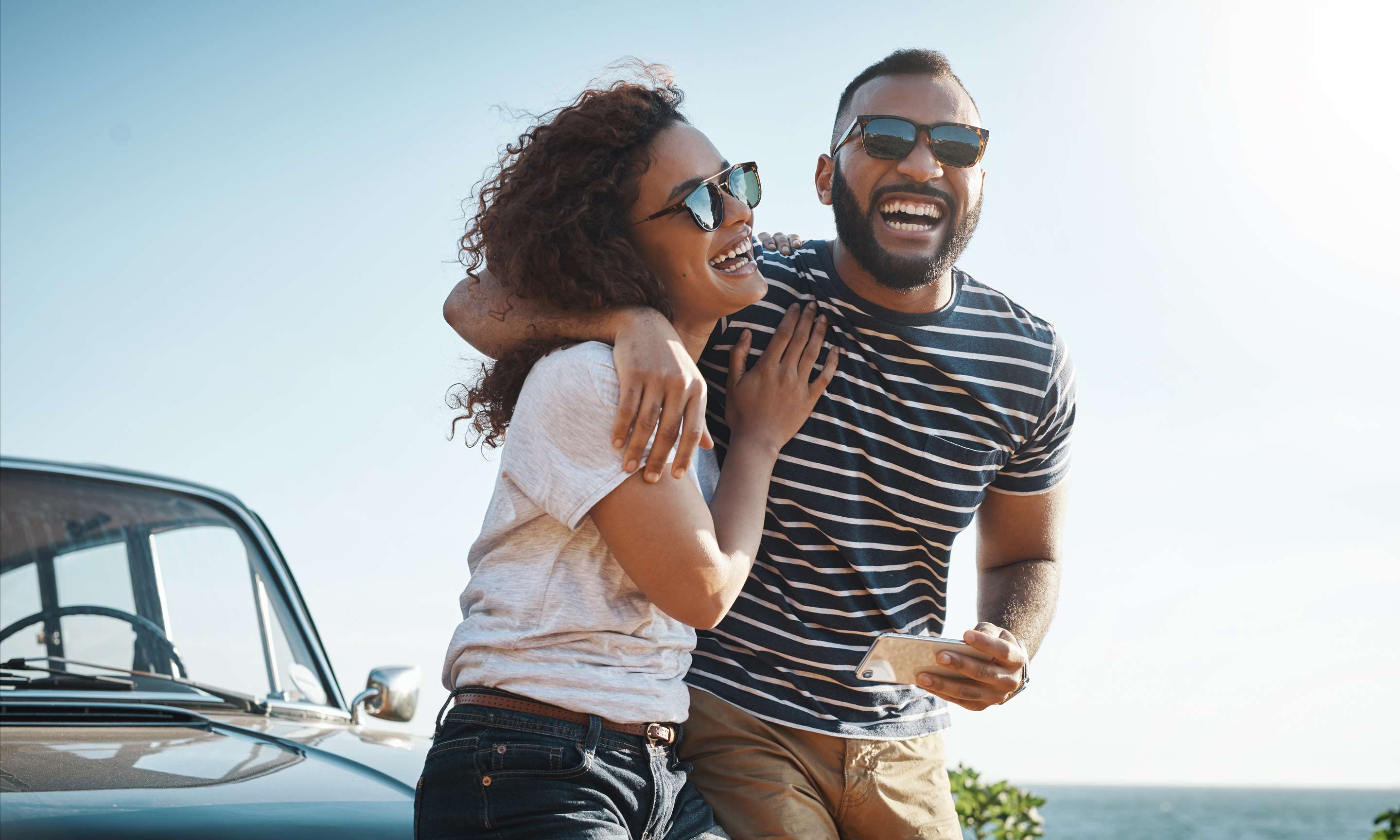 A couple laughing with bright blue sky in the background
