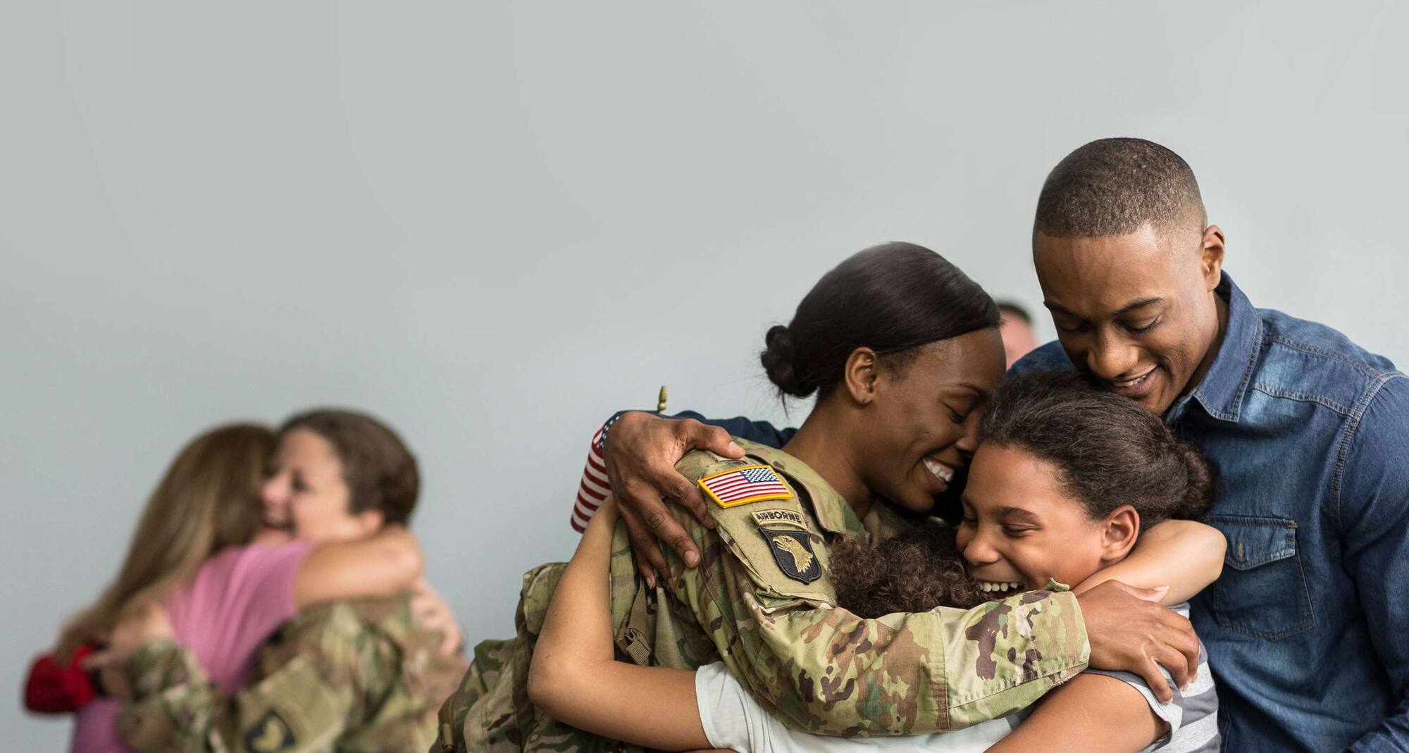 Militärkvinnor omfamnar sina familjer