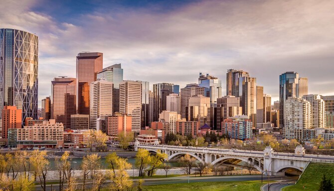 The evening sun shining on a beautiful skyline with a riverside park in the foreground.