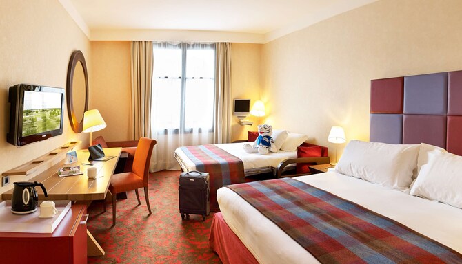 Radisson Blu Hotel Paris, Marne-la-Vallee — чемодан и игрушечный тигренок на кровати в люксе Family
