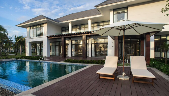 Outdoor pool deck with empty lounge chairs.