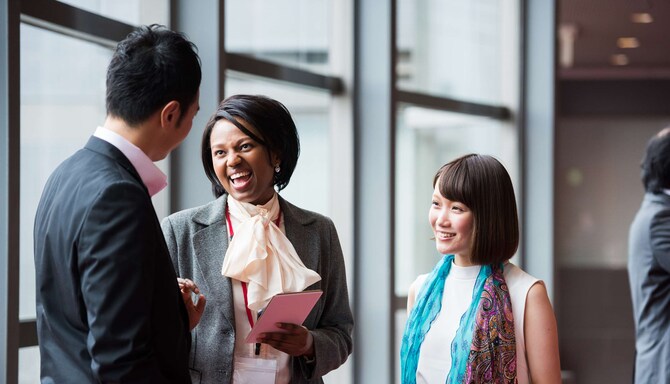 Business men and women laughing at a conference