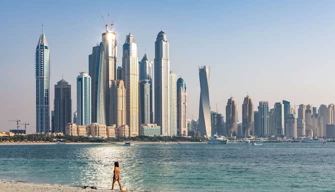 Blog images - 2023 - The four best places for vacation in October woman walking on a beach