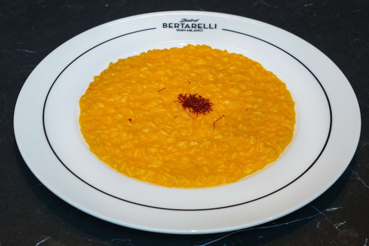 Blog images - 2023 - Culinary Tales Flavors of Milan with Luca Milanese Saffron Risotto Recipe risotto on a black table