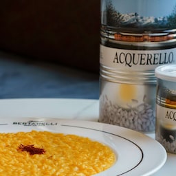 Blog images - Culinary Tales: Flavors of Milan with Luca - Milanese Saffron Risotto Recipe - risotto dish plated next to acquerello