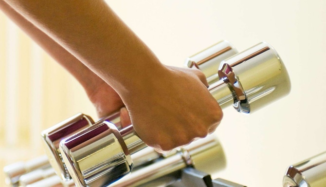 Fitness, Wellness & Spa - Gym - hands lifting free weights of stand