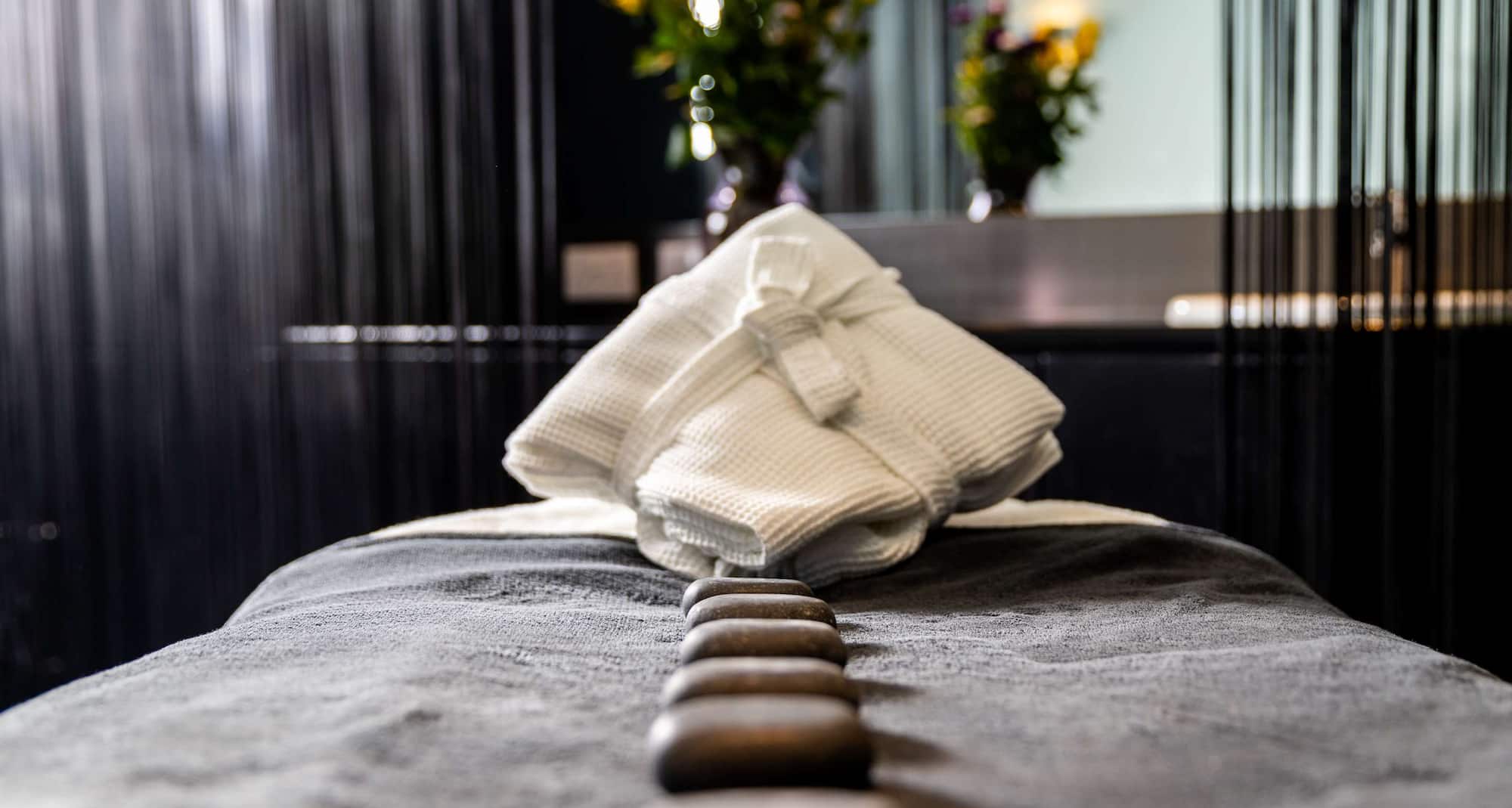 اللياقة البدنية والسبا والعناية بالصحة - سرير علاجات سبا مع تدليك بالحجر الساخن