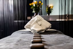 फिटनेस, वेलनेस और स्पा - हॉट स्टोन्स के साथ स्पा ट्रीटमेंट बेड