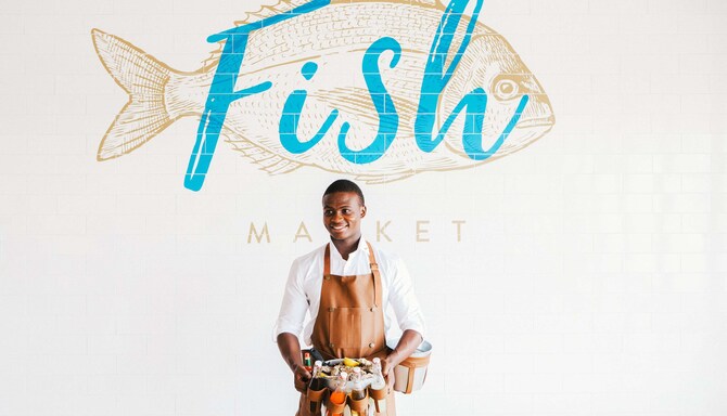 Radisson Blu Hotel, Dubai Deira Creek - Restaurant Fish Market, chef avec huîtres et huiles en face de l’enseigne au mur du restaurant