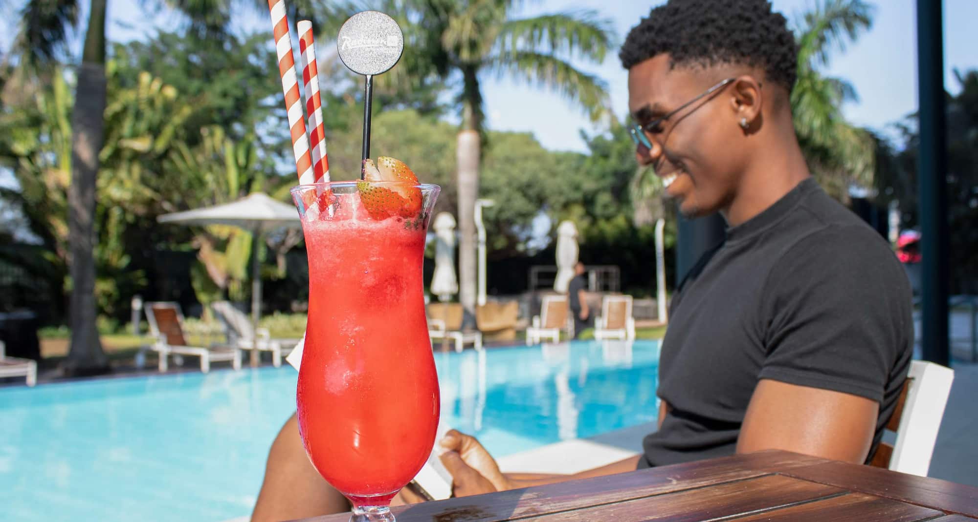 Man by pool with cocktail