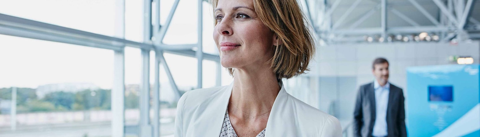 A business woman walking through an airport. - AMER Meetings - Get Rewarded Promotion