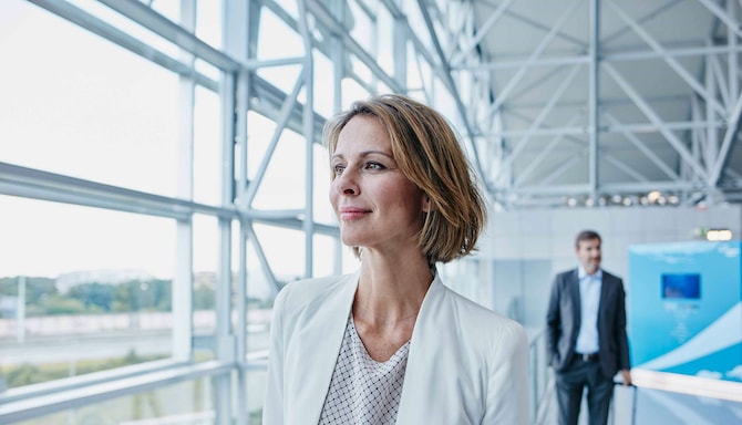 A business woman walking through an airport. - AMER Meetings - Get Rewarded Promotion