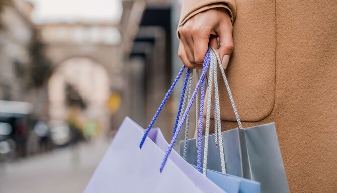 Hand of woman with shopping bags, while walking down the street