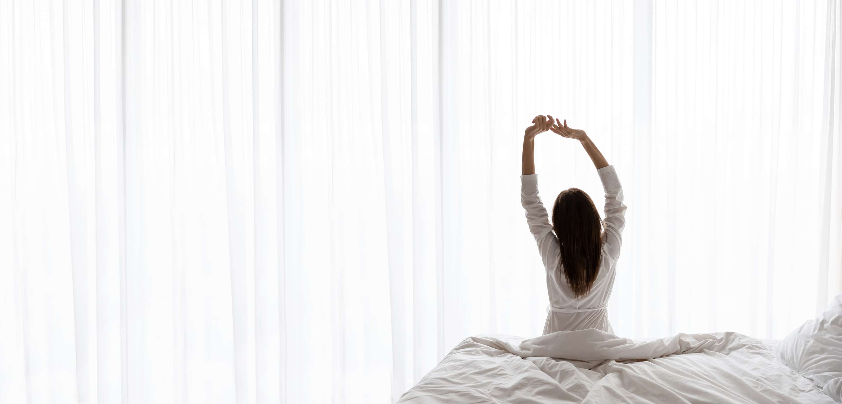 Woman stretching while getting out of bed