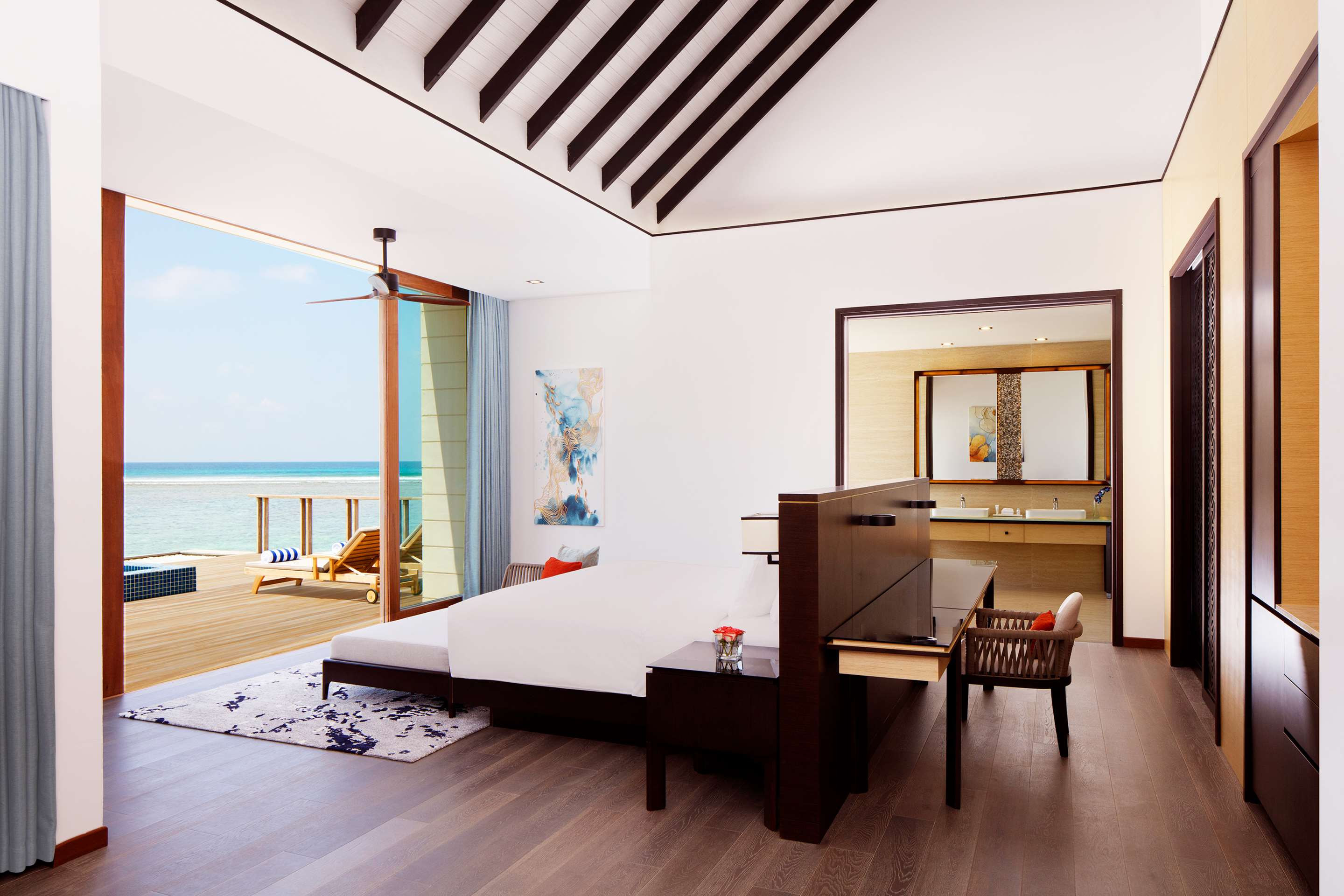 A serene hotel room that opens to a deck above the ocean