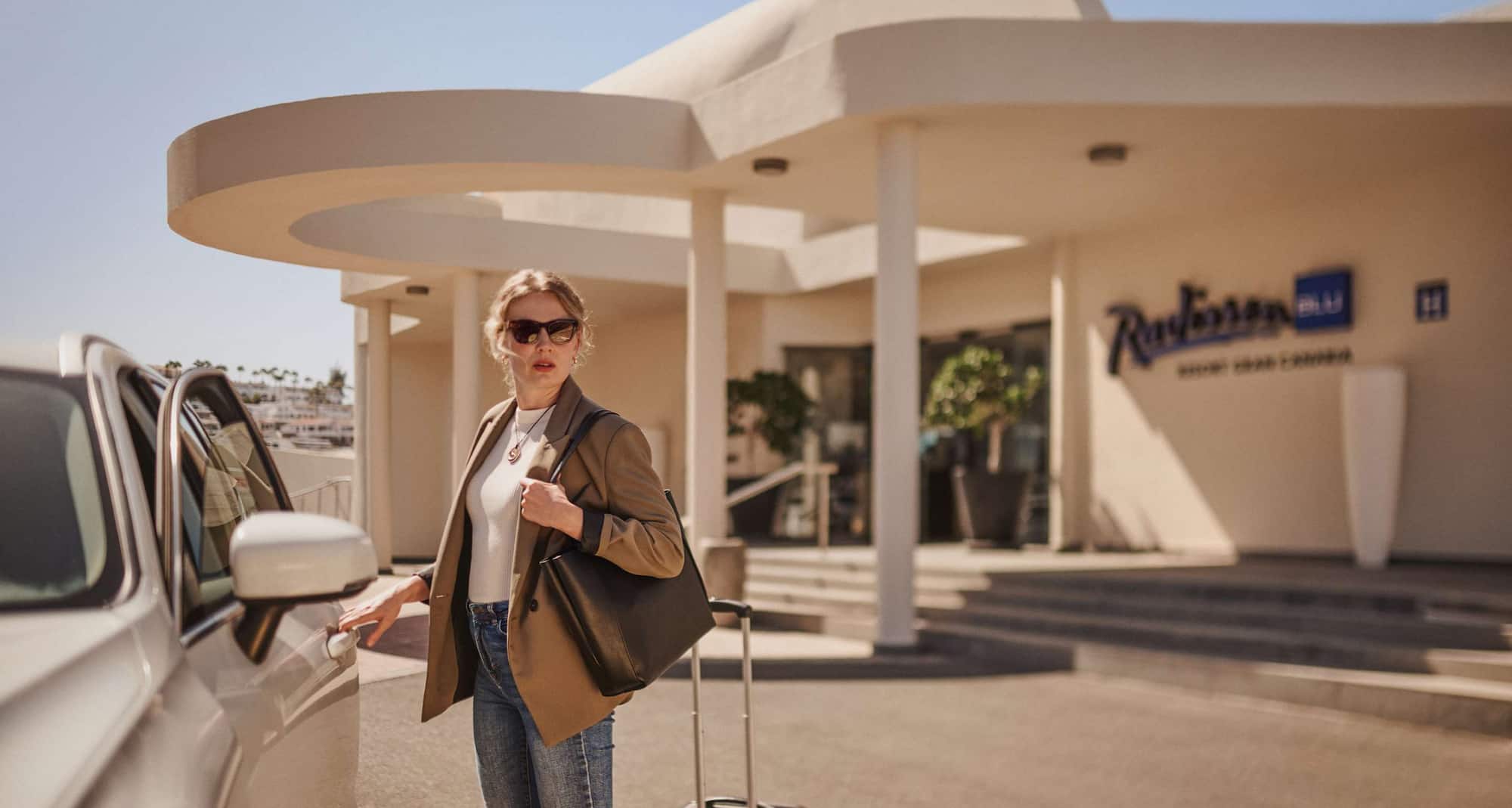 Radisson Rewards Brand - Member arriving in car rental - partners