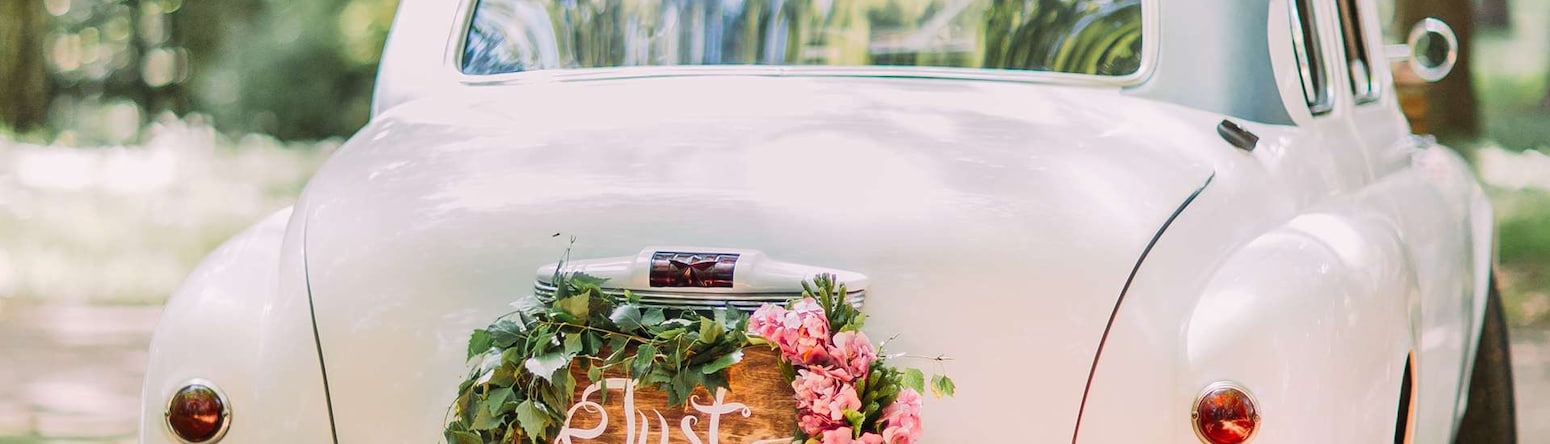 Bodas - Coche blanco con letrero de recién casados