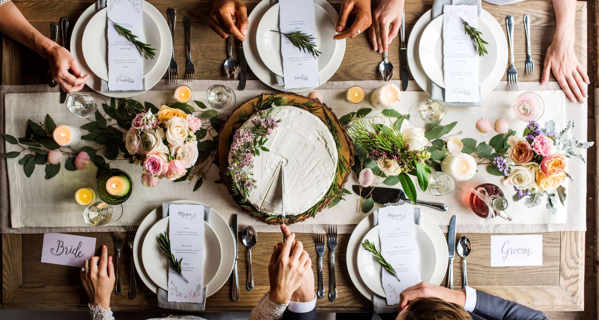 Weddings - Bride and groom cutting cake on wedding reception